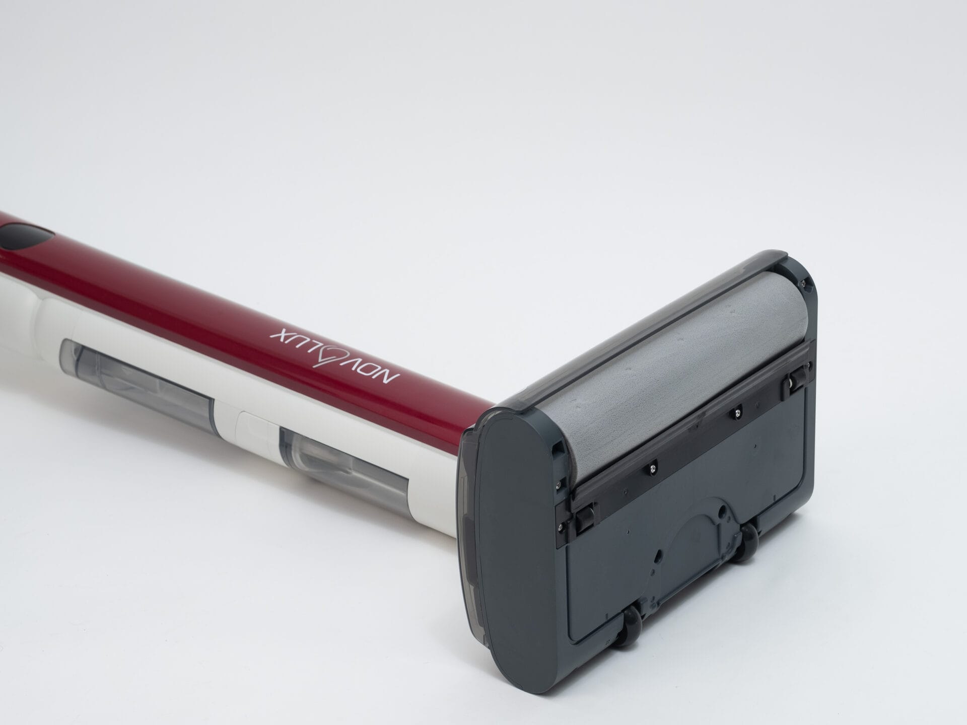 Eine Nahaufnahme des rot-weißen kabellosen Staubsaugers Novolux mit einem breiten schwarzen Reinigungskopf, der vor einem schlichten weißen Hintergrund gezeigt wird.